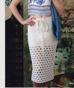 a woman in a crochet skirt and tank top