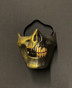 "This zombie half skull mask is hand painted in a brushed gold and solid black. Mask has unique style with raised detail and two-tone colors. Also, this mask is lightweight and has a foam backing and elastic band for a comfortable fit. Great addition to any Halloween zombie or skull style costume. Size 6.5\"W x 5.5\"H" Black Skull Shaped Mask For Masquerade, Black Skull Mask For Masquerade, Black Halloween Mask For Protection, Black Mask For Halloween Protection, Black Protective Mask For Halloween, Black Skull Mask For Halloween, Black Full Face Horror Mask, Black Horror Full Face Mask, Gold Halloween Costume Mask