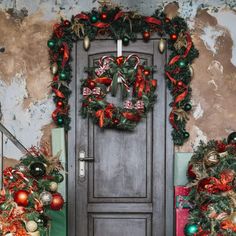 two christmas wreaths on the front door of a house decorated with red, green and gold ornaments