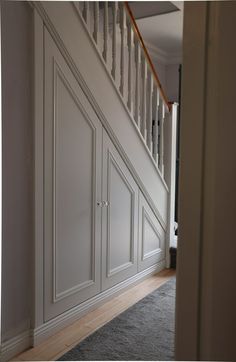 an empty room with white painted walls and stairs leading up to the second floor area