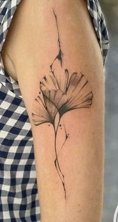 a black and white photo of a flower tattoo on the right arm, with an arrow coming out of it