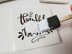 someone using a brush to paint the words on a piece of paper with black ink