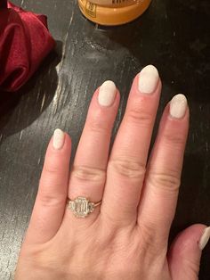 a woman's hand with white manicures and a ring on her finger