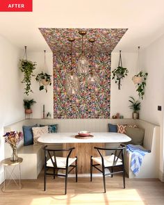 a dining room table with two chairs and a bench in front of a colorful wall