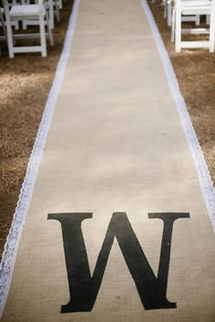 a long white aisle with chairs on each side and the letter w painted on it