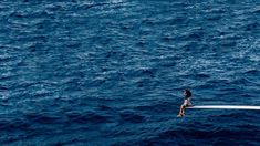 a person sitting on top of a boat in the ocean