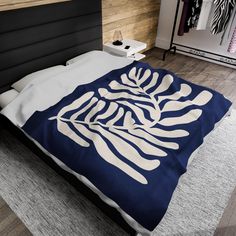 a bed with a blue and white comforter on top of it