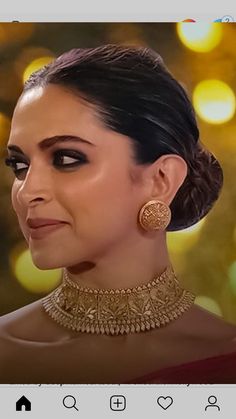 an image of a woman wearing a gold choker and matching earrings on her face