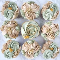 cupcakes decorated with pink and white frosting on a marble table top next to each other