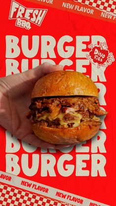 a hand holding a burger in front of a red background