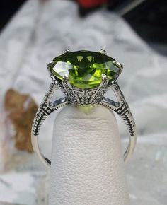 Natural Green Peridot Ring  100 Year Design#37 Made To Order This is a brand new Edwardian circa 1910 reproduction filigree ring in sterling silver. The round full cut high-quality approximately 6ct Natural green peridot is 12mm (just shy of 1/2th of an inch) in diameter (The 2ct Natural Peridot option is also available, the 2ct version of this ring has a 9mm gemstone, see least picture in set). The peridot is a genuine natural earth-mined gemstone and thus has slight minor inclusions inherent t Peridot Aesthetic, Elk Ivory, Stock Design, Order Design, Peridot Jewelry, Peridot Green, Buffet Food, Luxury Rings, Sterling Silver Filigree