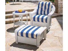 an outdoor chair and ottoman with blue and white striped fabric on it, in front of a stone patio