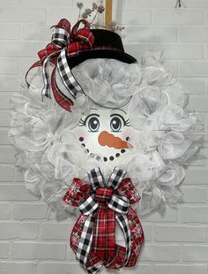 a snowman wreath hanging on a brick wall