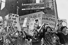 black and white photograph of protestors in new york city, with one woman holding up signs