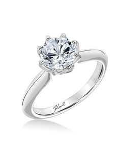 a white gold engagement ring with an oval cut diamond in the center and inscription on the side