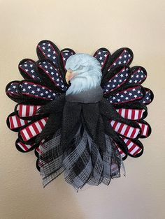 a wreath with an eagle and american flag colors on it is hanging on the wall