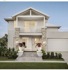 a two story house with white trim and stonework on the front, side and top floors