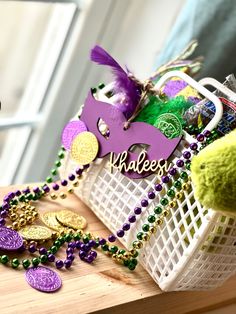 a mardi gras basket filled with beads and other items sitting on a table