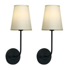 two lamps that are next to each other on a wall mounted light fixture with a white shade