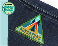 a patch on the back of a pair of jeans that says,'adventure '