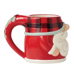 a red and black plaid mug with a santa clause on the side, sitting in front of a white background