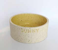 a yellow and white bowl with the word sunny written on it