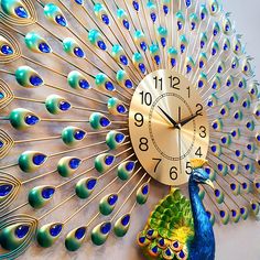 a clock that is on the side of a wall with a peacock's tail