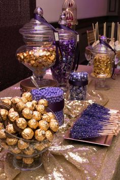 a table topped with lots of chocolate covered candies and lollipops on top of plates