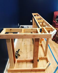 a workbench is being built in the middle of a room with hard wood flooring