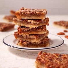 a stack of pecan bars sitting on top of a white plate