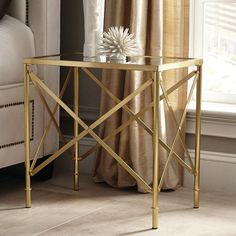 a gold metal table with a glass top