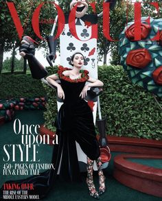 a woman in a black dress on the cover of a magazine, with roses around her neck