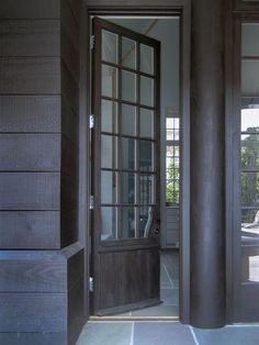 an open door leading into a room with wood paneling and glass panels on the walls