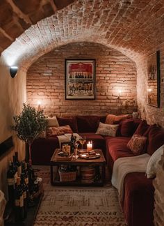 a living room filled with furniture and lots of bottles on the table in front of a brick wall