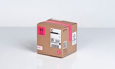 a cardboard box with a pink sticker on it