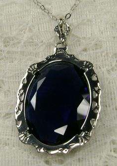 "Pendant Description Custom Inspired by Victorian era designs, I now offer this lovely Antique reproduction in sterling silver. The flawless simulated 22ct faceted blue sapphire is 24mm long (15/16th\") and 18mm in width (3/4th\"). The entire pendant is 1.5\" long and 7/8\" wide. The chain (if chosen) is between 16-18\" in length and is marked 925 as well. Notice the beautiful craftsmanship of the Victorian filigree setting. This pendant necklace is a true reproduction of and old Victorian cameo Classic Blue Pendant Jewelry, Handmade Sapphire Necklaces For Formal Occasions, Blue Jewelry With Large Pendant As Gift, Blue Jewelry With Large Pendant For Gift, Silver Sapphire Round Pendant Jewelry, Formal Blue Jewelry With Large Pendant, Blue Jewelry With Large Pendant For Formal Occasions, Classic Blue Engraved Jewelry, Classic Sapphire Jewelry Collectible