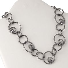 Ready-to-wear jewelry is perfect for gift-giving, counter sales or extending current jewelry lines. Necklace features gunmetal-plated steel with retro-inspired multi-size circle links. Gunmetal Chain Link Jewelry, Elegant Gunmetal Link Jewelry, Round Gunmetal Stainless Steel Jewelry, Oxidized Metal Necklaces, Adjustable Gray Metal Jewelry, Gunmetal Jewelry With Lobster Clasp In Metal, Nickel Free Metal Necklaces, Adjustable Gunmetal Jewelry With Chain, Adjustable Metal Chain Necklace