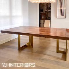 a dining room table with two chairs and a chandelier