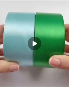 someone is holding two rolls of green tape