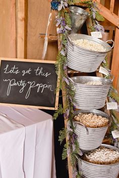 a bunch of buckets filled with food next to a sign that says let's get this party on