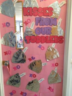 a door decorated with paper hearts and other things that say kisses from our toddlers