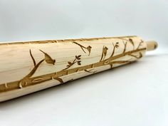 a close up of a wooden bat with birds on it's back and branches painted on the side