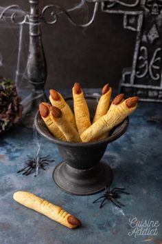 some bread sticks are in a bowl on a table with spider webs and spooky decorations