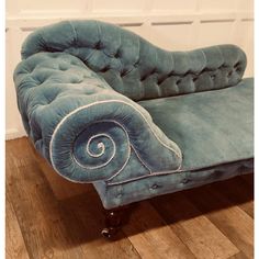 a blue chaise lounge chair sitting on top of a hard wood floor