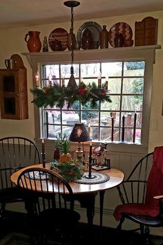 a dining room table and chairs in front of a window with christmas decorations on the windowsill