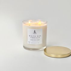 a white candle sitting next to a gold plate