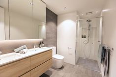 a bathroom with a sink, toilet and shower stall in the middle of the room