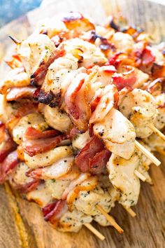 chicken and bacon skewers with toothpicks on a wooden cutting board, ready to be eaten