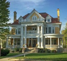 a large white house sitting on top of a lush green field