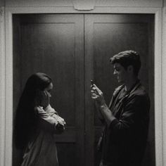 a man and woman standing in front of a door